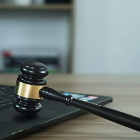 A gavel rests on a laptop keyboard, representing the intersection of law and technology.