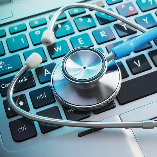 Stethoscope placed on top of a laptop keyboard, representing data security in healthcare